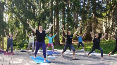 Üben Sie gemeinsam auf der Yoga-Plattform mitten im Grünen