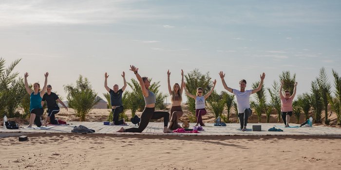 Yogaplattform in der Wüste mit Yogis