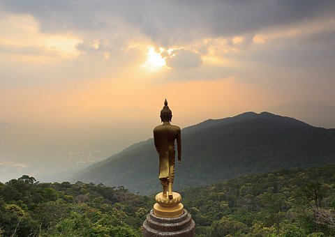 Goldene Buddha-Statue mit Blick auf Sonnenaufgang über den Bergen
