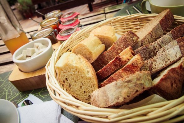 Aufgeschnittenes Brot im Brotkorb und Aufstriche
