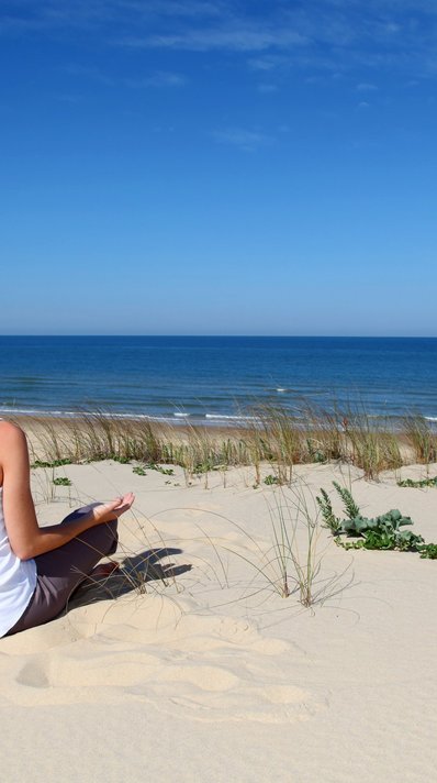 Bei einer Meditation in den Dünen ganz bei sich sein