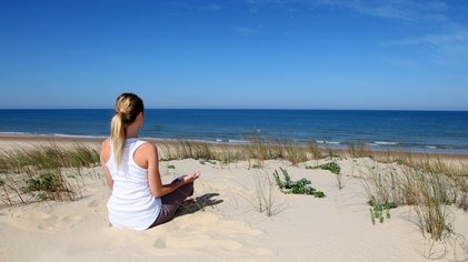 Bei einer Meditation in den Dünen ganz bei sich sein