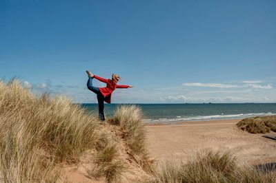 Yoga üben inmitten von Dünen