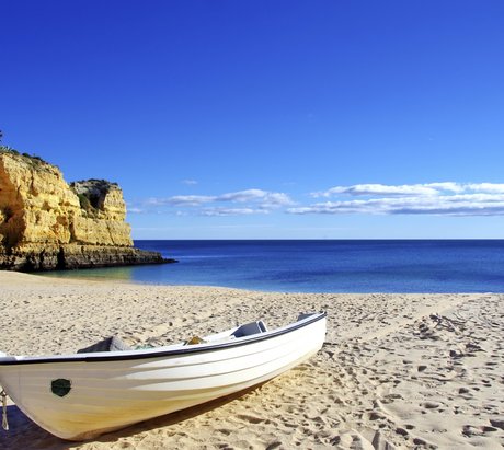 Ein kleines Fischerboot am Strand an der Algarve, Portugal