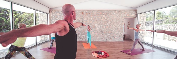 Eine Gruppe an Yogis im stehenden Krieger 2
