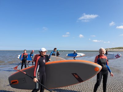 Strahlende Gesichter nach dem Stand Up Paddeling auf dem Meer