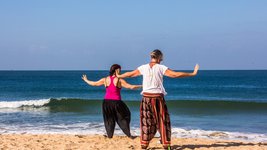 Zwei Frauen üben Qi Gong an einem Strand