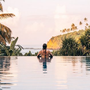 Eine Frau im Pool Blick auf das Meer