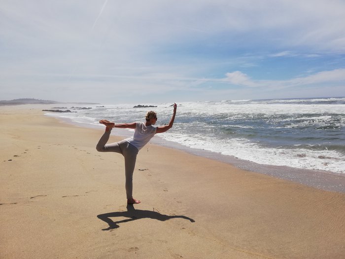 Eine Frau in der Dancer Pose am Strand