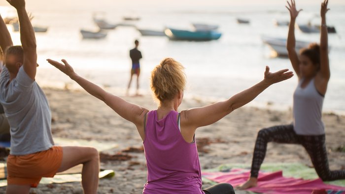Eine Gruppe übt Yoga am Strand
