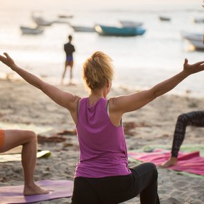 Eine Gruppe übt Yoga am Strand