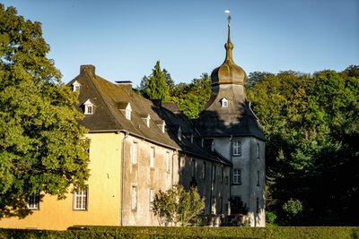 Das Schloss Melschede liegt umgeben von Buchenmischwäldern in einem weiten Tal im Sauerland
