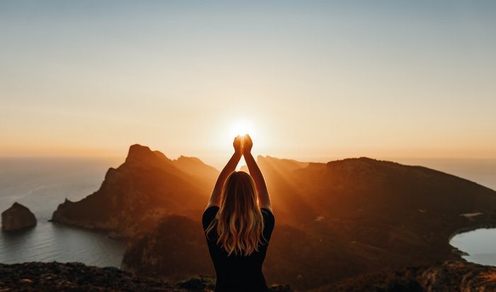 Junge Frau übt Yoga bei Sonnenuntergang