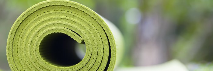 Eine grüne Yoga-Matte auf einer Wiese