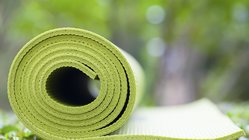 Eine grüne Yoga-Matte auf einer Wiese