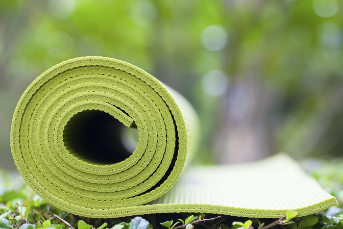 Eine grüne Yoga-Matte auf einer Wiese