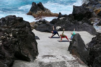 Zusammen Yoga üben zwischen den Felsen der Azoren