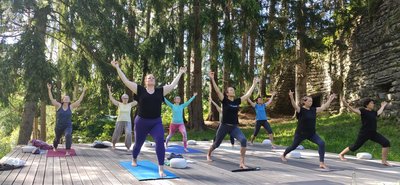 Üben Sie gemeinsam auf der Yoga-Plattform mitten im Grünen