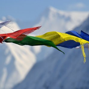 Bunte Fahnen vor schneebedeckten Bergen