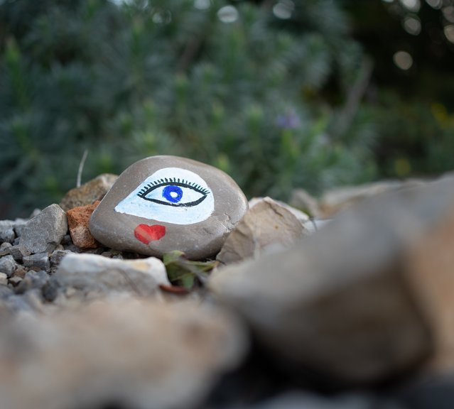 Ein Stein mit einem gemalten Auge zwischen anderen Steinen
