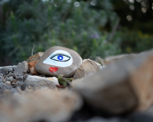 Ein Stein mit einem gemalten Auge zwischen anderen Steinen