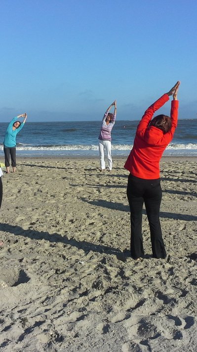 Entspannen Sie bei einer Yoga-Einheit in einer Gruppe am Strand Entspannen Sie bei einer Yoga-Einheit in einer Gruppe am Strand