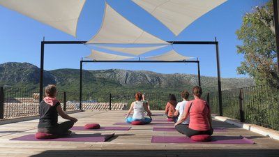 Üben Sie Yoga auf der Plattform mit Blick auf das Karstgebirge