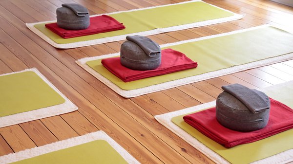 Nahaufnahme von Yogamatten und Yogakissen in einem Yogastudio