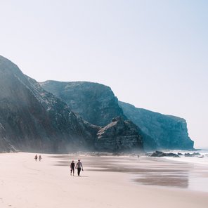 Ein Strand mit weißem Sand und einer Steilküste