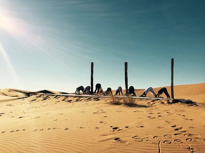 Eine Runde Yoga inmitten der Sahara Wüste üben