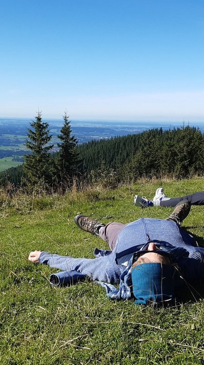 Sich nach einer Wanderung auf den grünen Bergwiesen ausruhen