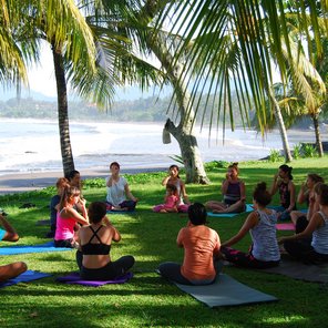 Yoga Gruppe in einer Wiese am Meer