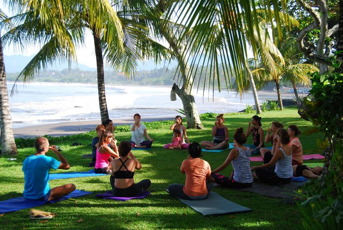 Yoga Gruppe in einer Wiese am Meer