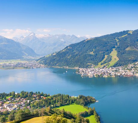 Ein blauer See zwischen Bergen und einer Stadt