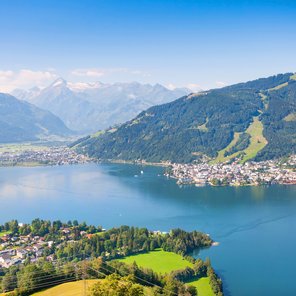 Ein blauer See zwischen Bergen und einer Stadt