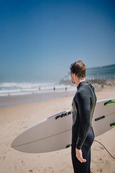 Surfer mit Surfbrett am Strand