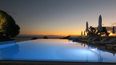Wie harmonisch, der beleuchtete Pool des Hotels vor dem Sonnenuntergang über dem Horizont. 