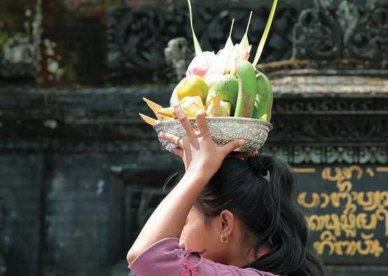 Frau mit einer silbernen Schale Obst auf dem Kopf
