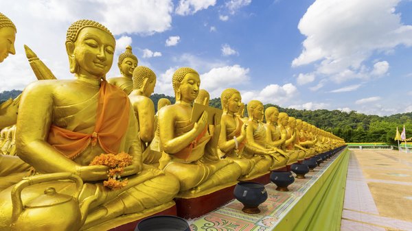 Eine Reihe von goldenen Budda Statuen auf einer Tempelanlage