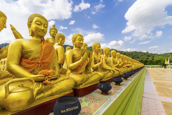 Eine Reihe von goldenen Budda Statuen auf einer Tempelanlage