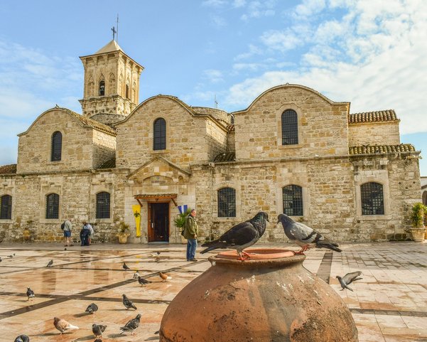 Eine aus Stein erbaute Kirche auf einer Plattform mit vielen Tauben