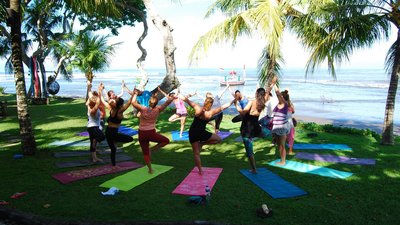 Yoga in der Gruppe am Strand von Bali 