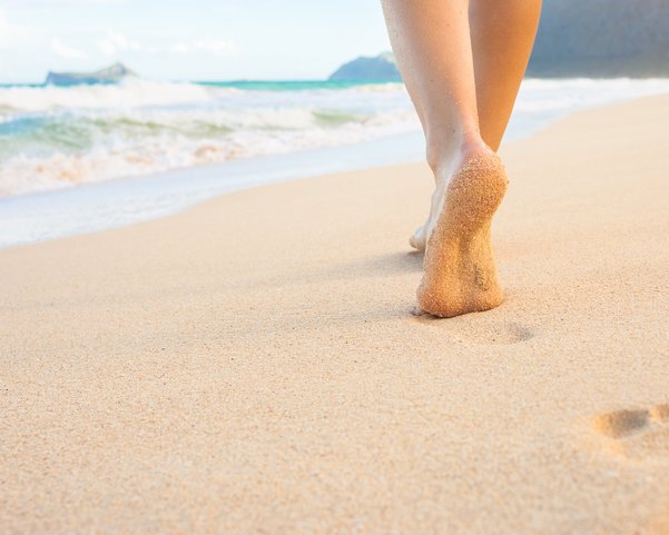 Eine Frau geht an einem Strand spazieren