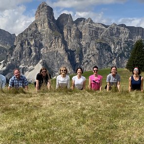 Yogagruppe vor Bergkulisse