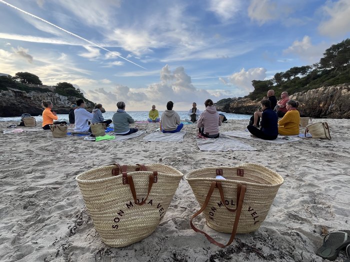 Gruppe meditiert am Strand
