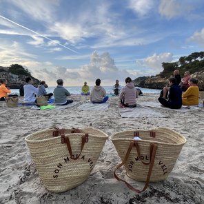 Gruppe meditiert am Strand