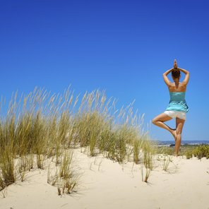 Yogapose, der Baum, am Strand üben