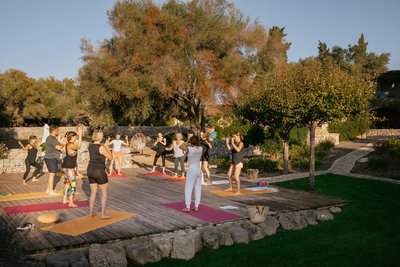 Yoga Übende auf einer Yogaplattform unter blauem Himmel