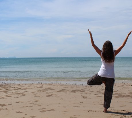 Frau in Baum Asana am Strand