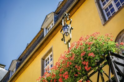 Bunte Blumen säumen die Hauswand des Schlosses Melschede